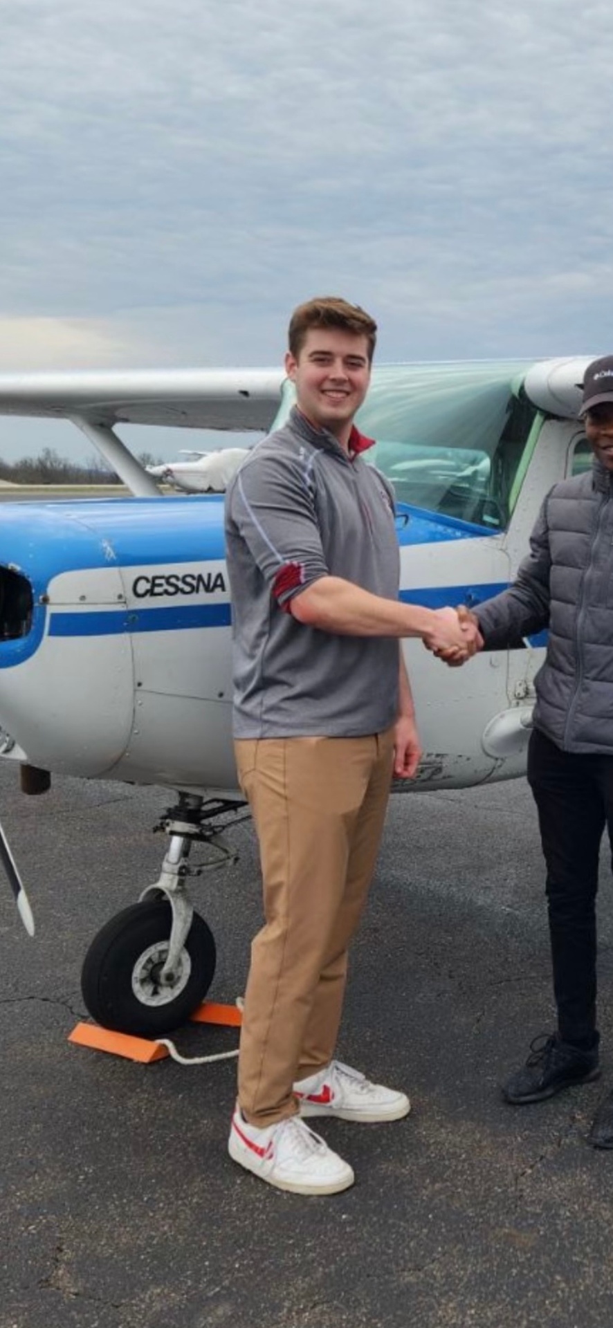 TJ Larson shaking hands with a client in front of a Cessna aircraft