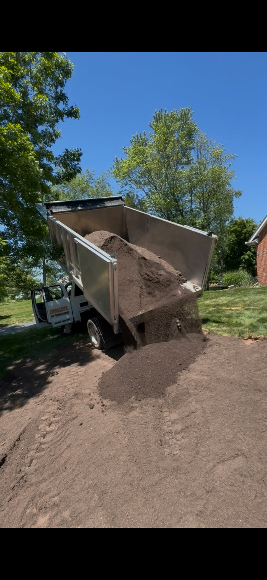 Larson Landscape dump truck delivering a load of screened topsoil