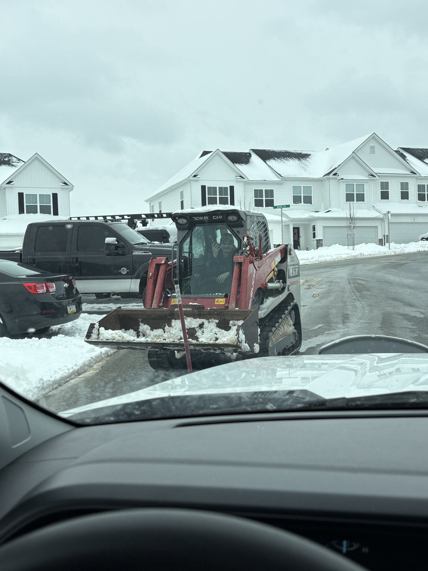 Larson Landscape Takeuchi skid steer clearing snow in an HOA community