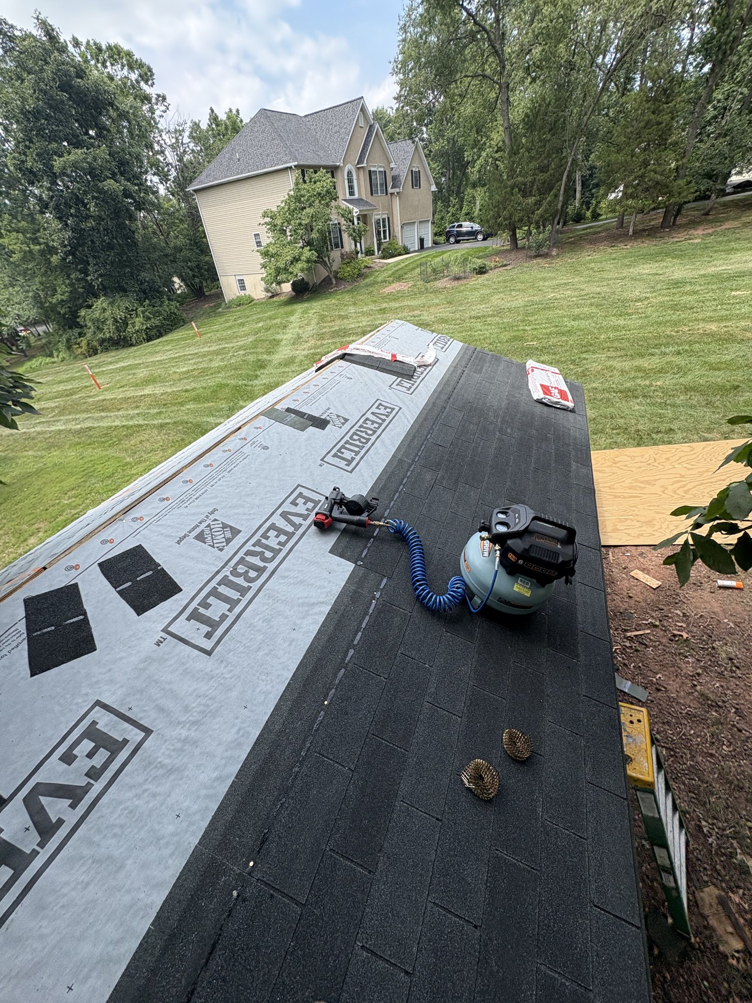 Exterior home repair project in progress with new underlayment and shingles
